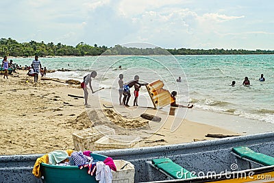 Caribbean people playing with a fridge in the beach. Rincon del mar, San Onofre. Colombia Editorial Stock Photo