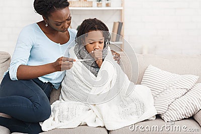 Mother measuring temperature of her sick daughter with thermometer Stock Photo