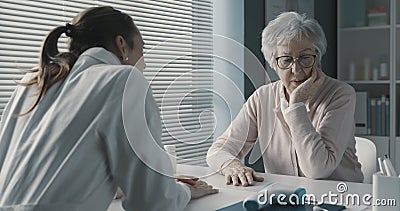Caring doctor assisting a senior patient Stock Photo