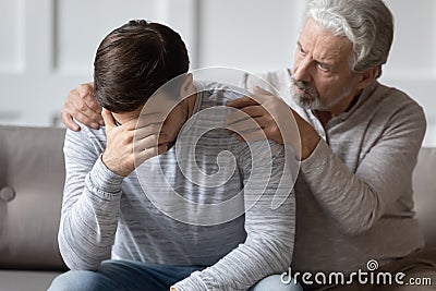 Caring elderly father comfort upset adult son Stock Photo
