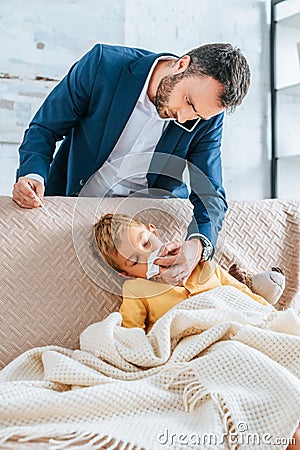 caring father wiping nose of sick Stock Photo