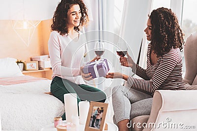 Caring girl presenting wonderful gift to her best friend Stock Photo