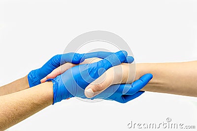 Caring hands with blue medical gloves giving comfort and holding hands. Stock Photo