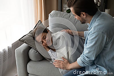 Caring husband cover sleeping on sofa beautiful wife with plaid Stock Photo