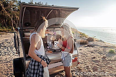 Caring loving man pouring some hot tea for girlfriend living in trailer together Stock Photo