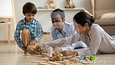 Caring mixed race parents building dino park with preschooler son Stock Photo