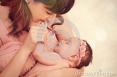 Caring mother kissing little fingers of her cute sleeping baby g Stock Photo