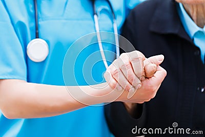 Caring Nurse holding Elderly Hands Stock Photo