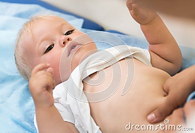 Caring pediatrician doing massage to little girl Stock Photo