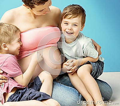 Caring pregnant mom embracing her lovely sons Stock Photo