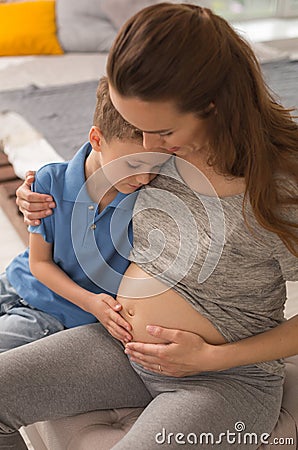 Caring pregnant mother hugging her little cute son Stock Photo