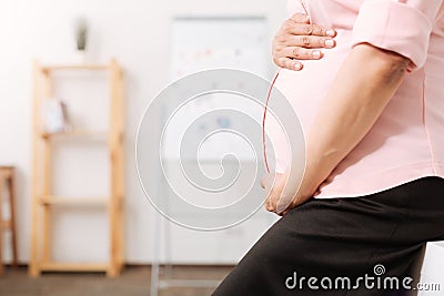 Caring pregnant mother touching her belly Stock Photo