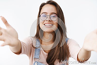 Caring tender and attractive feminine woman in glasses extending arms towards camera to give kiss and hug wanting hold Stock Photo