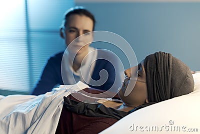 Caring woman assisting her friend with cancer at hospital Stock Photo