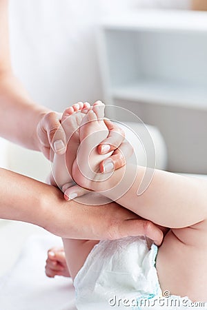 Caring young mother changing her baby diaper Stock Photo