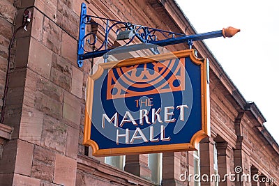 Market Hall painted hanging sign on the outside facade of an old stone building Editorial Stock Photo