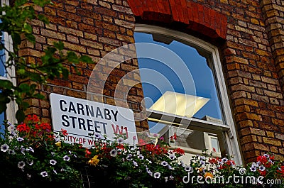 Carnaby Street sign with window and potted flowers London England Editorial Stock Photo