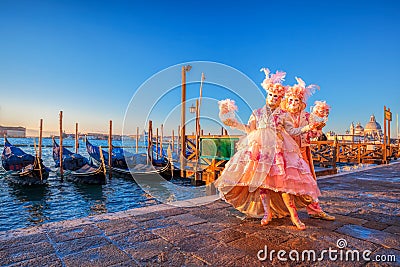 Carnival masks against gondolas in Venice, Italy Stock Photo