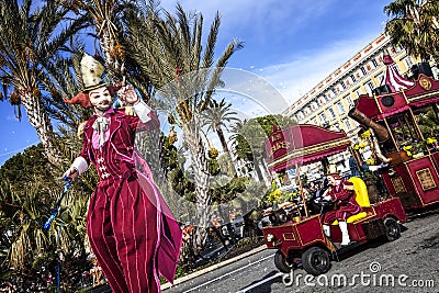 Carnival of Nice, Flowers` battle. A wader in red costume and a little train Editorial Stock Photo