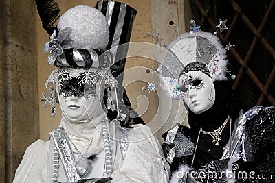 Carnival pair black-white-silver mask and costume at the traditional festival in Venice, Italy Editorial Stock Photo