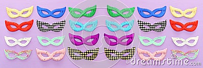 Carnival party banner celebration concept with collection of colorful masks over purple wooden background. Top view. Flat lay Stock Photo