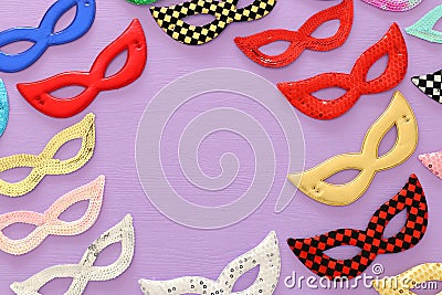 carnival party celebration concept with collection of colorful masks over purple wooden background. Top view. Flat lay. Stock Photo