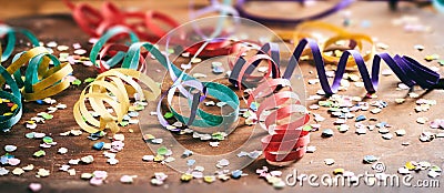 Colorful confetti and serpentines on wooden background Stock Photo