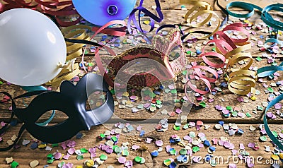 Carnival party. Masks, confetti and serpentines on wooden floor Stock Photo