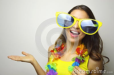 Carnival time. Young woman with big funny sunglasses and carnival garland smile at camera and show your product or text Stock Photo