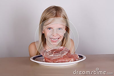 Carnivore keto diet concept - little blond girl eating raw meat Stock Photo