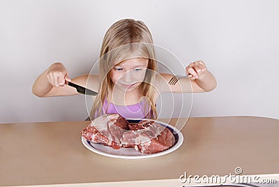 Carnivore keto diet concept - little blond girl eating raw meat Stock Photo