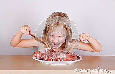 Carnivore keto diet concept - little blond girl eating raw meat Stock Photo