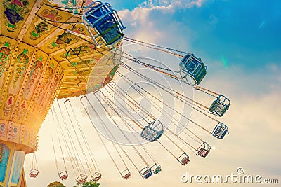 carousel ride spins fast in the air at sunset - a swinging carousel fair ride at dusk Stock Photo