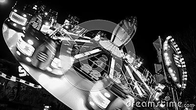 Carousels at amusement fair at night in black and white Editorial Stock Photo