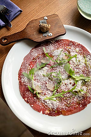 Carpaccio with parmesan, truffles and arugula on a white plate Stock Photo