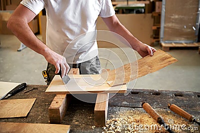 Carpenter applying glue to attach briar root panel Stock Photo