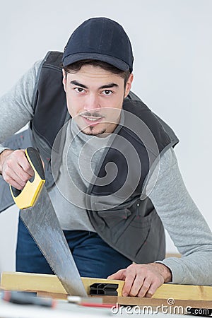 Carpenter cuts wood with handsaw Stock Photo