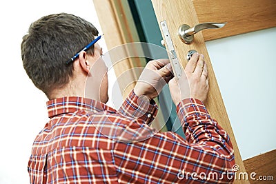 Carpenter at door lock installation Stock Photo