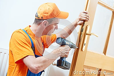 Carpenter at door lock installation or repair Stock Photo