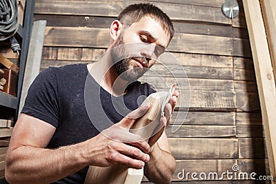 Carpenter equals polishes wooden board Stock Photo