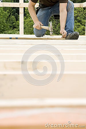 Carpenter Hammering Nail into Deck Stock Photo