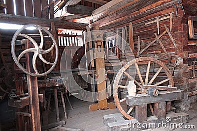 Carpenter historical workplace with some wooden wagon wheels, vertical stand saw, various scales and other tools. Stock Photo