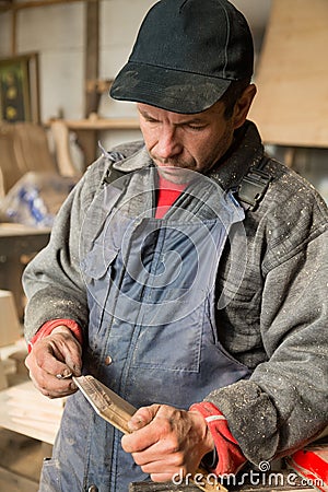 Carpenter holding a wooden piece of furniture Stock Photo