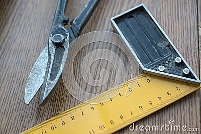 Carpenter home tool concept. Home renovation. Close-up of carpentry scissors and square on a wooden surface. Selective focus, Stock Photo