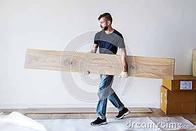 Carpenter man installing wooden floor Stock Photo