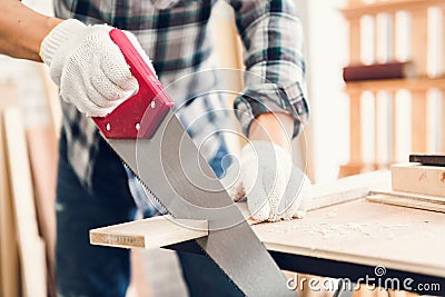 Carpenter Man is Working Timber Woodworking in Carpentry Shop, Craftsman is Saw Cutting Timber Frame for Wooden Furniture in Stock Photo