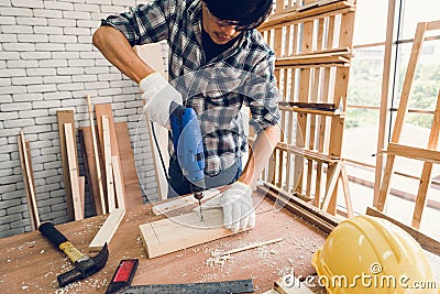 Carpenter Man is Working Timber Woodworking in Carpentry Shop, Craftsman is Screw Coring Timber Frame for Wooden Furniture in Stock Photo