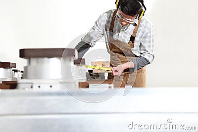 Carpenter man works with wooden planks in the joinery, measure with meter, with computer numerical control center, cnc machine, Stock Photo