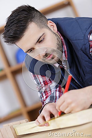 Carpenter measures and marks length wood Stock Photo