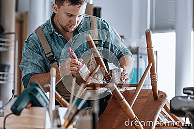 Carpenter painting wooden chair Stock Photo